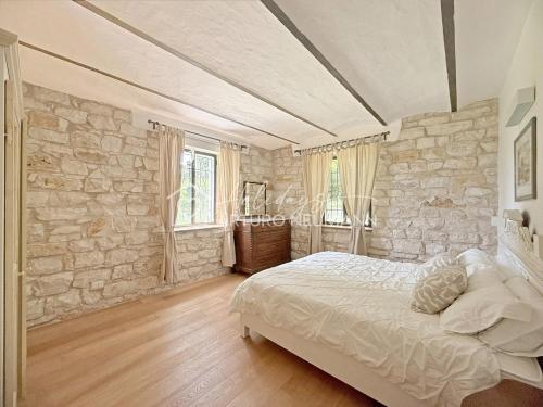 a bedroom with a stone wall and a bed at 207 - VILLA FERNANDA - Bilocale di charme al piano terra immerso nel verde, in centro e a pochi passi dal mare SPIAGGIA AL WHITE BEACH CLUB IN OMAGGIO dal lun al ven dal 24-08 in Sirolo