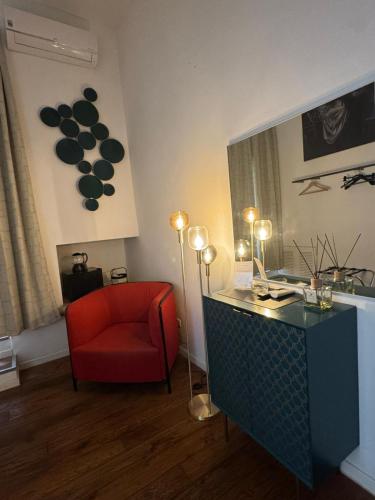 a living room with a red chair and a mirror at D'Aaragona 56 in Conversano