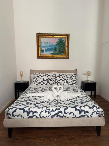 a bed in a bedroom with a picture on the wall at D'Aaragona 56 in Conversano