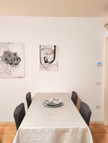 a dining room with a table with chairs and paintings at VistaMare Bluemar - Garden & Sea in Cattolica