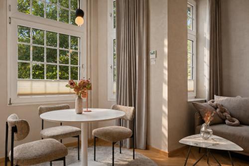 a living room with a table and chairs and a couch at Stylish City Center Escape- Where Modern Elegance Meets History in Trier