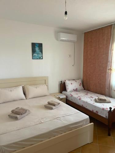 a bedroom with two beds and a window at Mekli Guesthouse in (( Shën Ded Gjoni ))