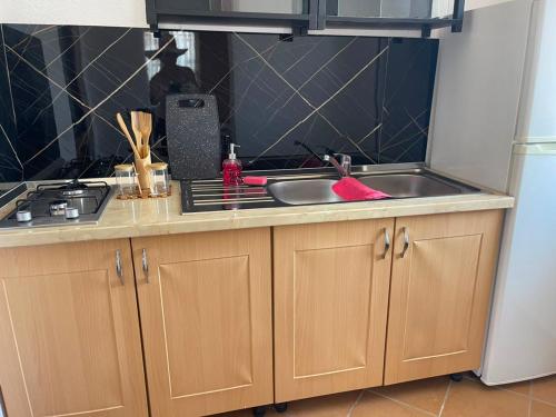 a kitchen counter with a sink and a stove at Mekli Guesthouse in (( Shën Ded Gjoni ))