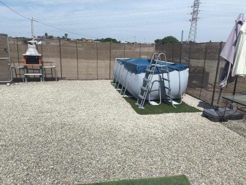 a bathtub sitting on the ground next to a fence at Casa Campo Gerena in Sanlúcar de Barrameda