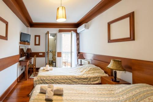 a hotel room with two beds and a mirror at Boutique Hotel 89 in Peje