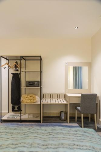 a bedroom with a bed and a desk and a mirror at هوليدي الخليج الفندقية Holiday Alkhaleej in Riyadh