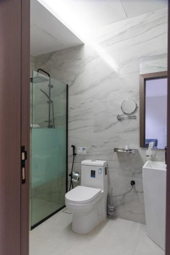 a bathroom with a toilet and a glass shower at هوليدي الخليج الفندقية Holiday Alkhaleej in Riyadh