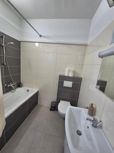 a bathroom with a tub and a toilet and a sink at Barlang utca Villa in Cserszegtomaj