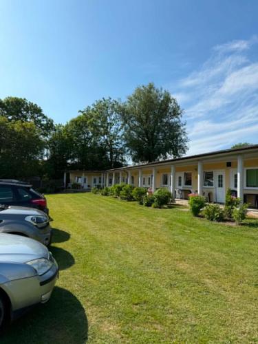 a row of cars parked in front of a building at POMERANIA Pokoje U Oliwii in Rewal