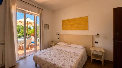 a bedroom with a bed and a sliding glass door at Hotel Aragonese Ischia in Ischia Town