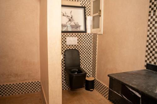 a bathroom with a toilet and a picture on the wall at Nassau House Marrakech in Mellah Bakka