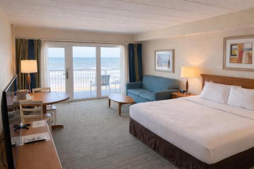 a hotel room with a bed and a balcony at The Sea Ranch Resort in Kill Devil Hills