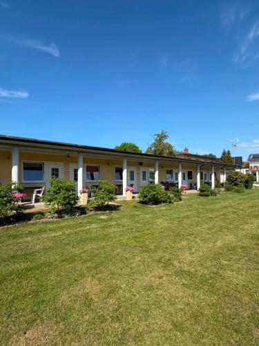 a building with a large yard in front of it at POMERANIA Pokoje U Oliwii in Rewal