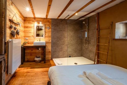 a bathroom with a bed and a shower and a sink at Les Gîtes de Sprimont - Le Cottage in Sprimont