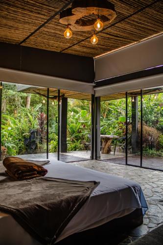 a bedroom with a large bed in front of windows at Glamping Salento in Salento