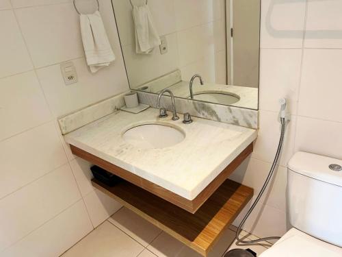 a bathroom with a sink with a mirror and a toilet at Flat & Suite Premium - Rio Centro - Barra - Farmasi Arena in Rio de Janeiro