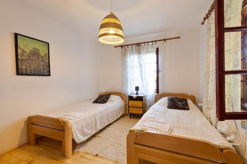 a bedroom with two beds and a chandelier at Tri breze Vodanj in Vodanj