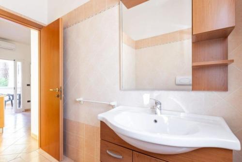 a bathroom with a white sink and a mirror at Villaggio Baia Dei Lombardi in Vieste
