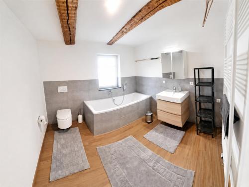 a bathroom with a tub and a toilet and a sink at Casa Anno 1782 in Markdorf