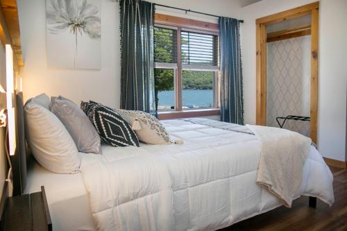 a bedroom with a white bed with pillows and a window at The View at Harbor Lights in Hammondsport