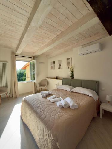 a bedroom with a large bed with towels on it at La Dimora Di Roberta in Montalcino