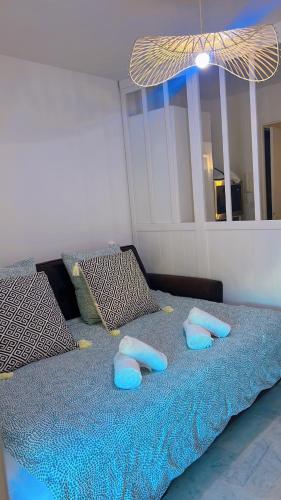 a bedroom with a bed with blue pillows on it at 100m de la plage in La Grande Motte