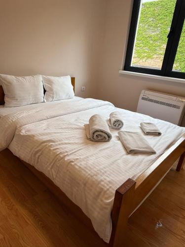 a bed with towels and towels on it with a window at Apartmani Ljupko in Pančevo