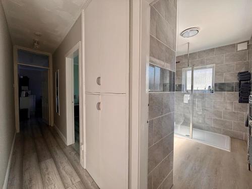 a bathroom with a walk in shower and a glass door at Orient Short Stay in Holyhead
