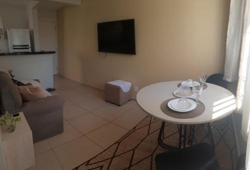a living room with a white table and a tv at Cantinho da Deusa in São José de Ribamar