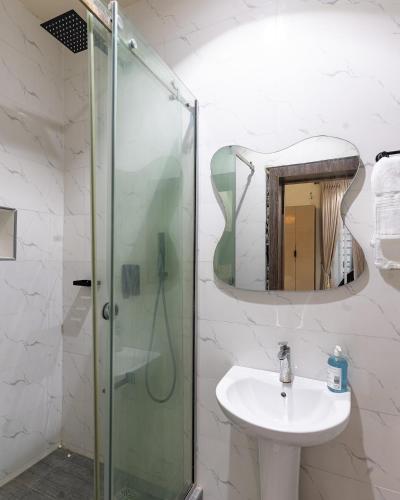 a bathroom with a shower and a sink and a mirror at Mirage in Lekki