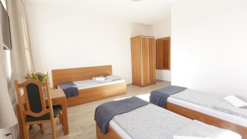 a bedroom with two beds and a desk and a chair at Baltic Resort - Korsarz in Darłowo