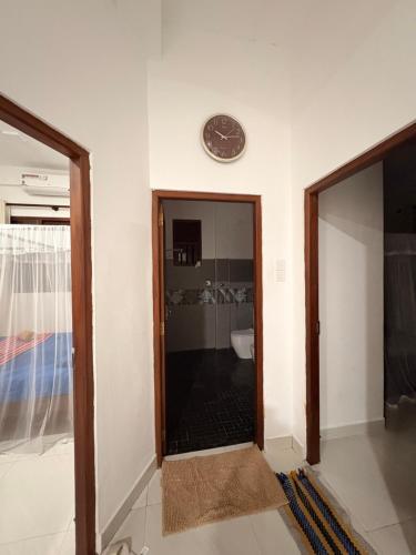 a room with a clock on the wall and a glass door at WILSON VILLA in Hikkaduwa