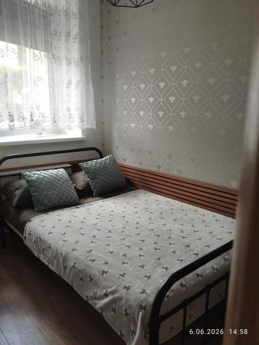 a small bed in a room with a window at Apartament Miodownik in Międzylesie