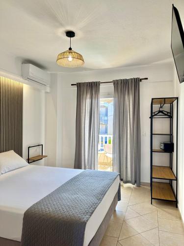 a bedroom with a large bed and a window at Melis Studios in Kallithea Halkidikis