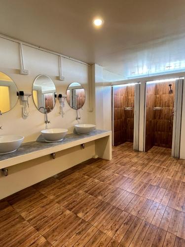 a bathroom with three sinks and two mirrors at Wonderful inn in Pattaya