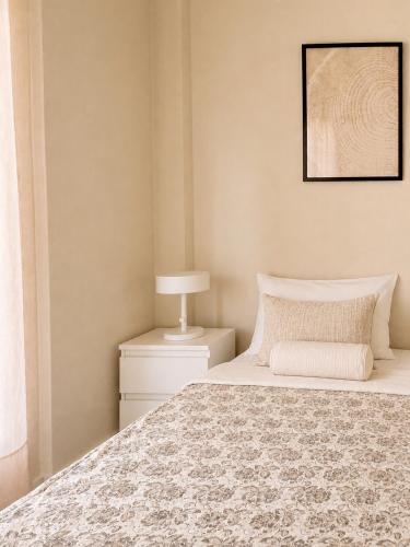 a bedroom with a bed and a lamp on a night stand at Agapidis Apartment in Hanioti