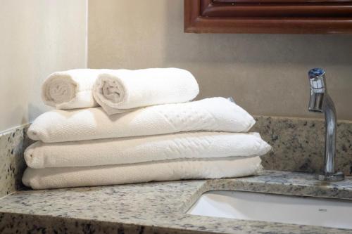 a stack of towels on a counter next to a sink at Poty Praia Hotel in Porto Seguro