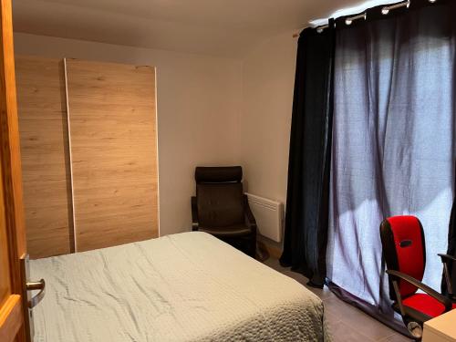 a bedroom with a bed and a chair next to a window at Logis Sol Levante in Arles-sur-Tech