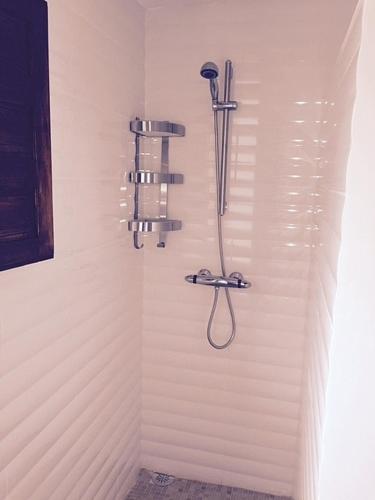 a shower in a bathroom with a light on the wall at Stunning views, 3 bed, private pool, olive grove in Iznájar