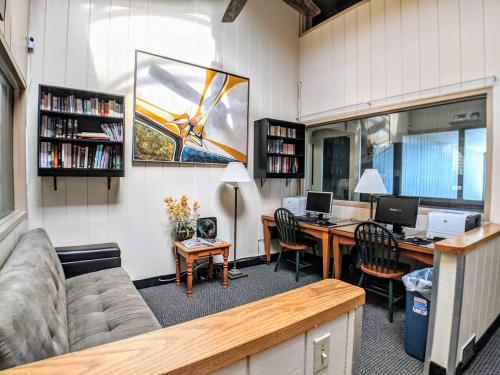 an office with a couch and a desk with two computers at Cedar Lodge Condo with Private Balcony & Full Kitchen in Laconia