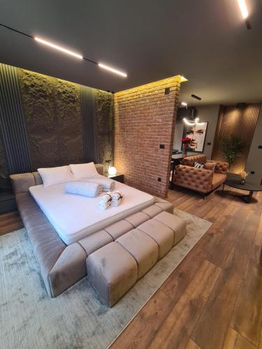 a large bed in a room with a brick wall at MOCCA Lux Suite in Bitola