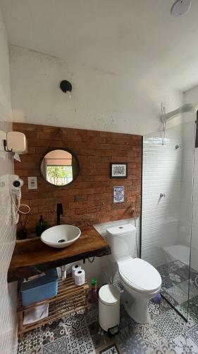 a bathroom with a white toilet and a sink at Chalés Calima in Lençóis