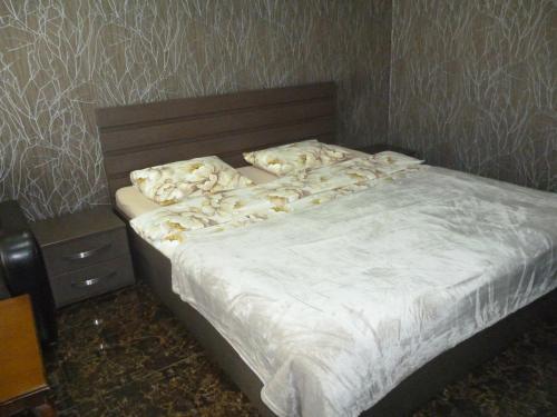 a bed with white sheets and pillows in a bedroom at batumi orbi sea tawers in Batumi