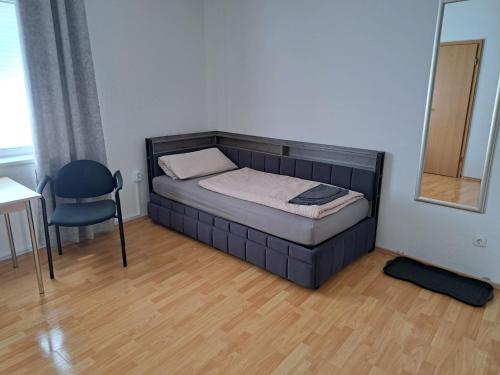 a small bedroom with a bed and a chair at Varus Apartments in Detmold