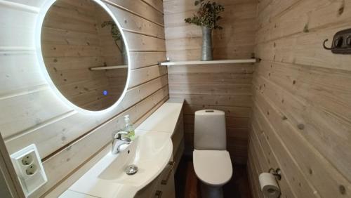 a bathroom with a toilet and a sink and a mirror at Genuine Beach House and Sauna in Pello