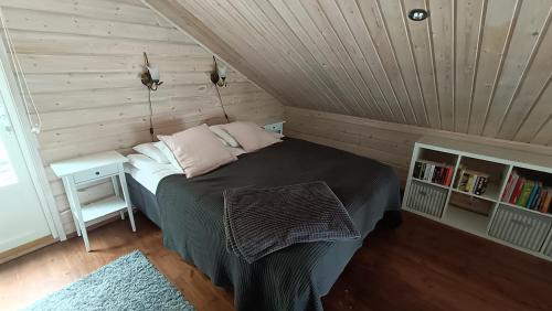a bedroom with a bed and a book shelf at Genuine Beach House and Sauna in Pello