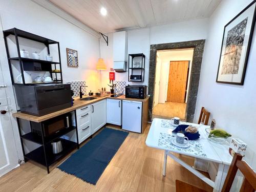a kitchen with a table and a small kitchen with a dining room at Casinha do Solar in Angra do Heroísmo