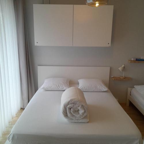 a white bed with a white towel on it at Santhooft B , bus 514 Nieuwpoort bad in Nieuwpoort