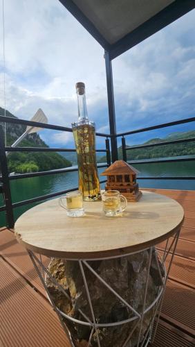 a table with a bottle and candles on a balcony at Splav Rio in Aluga
