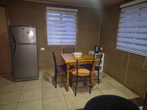 a kitchen with a table and chairs and a refrigerator at Cabaña Gazul in Porvenir